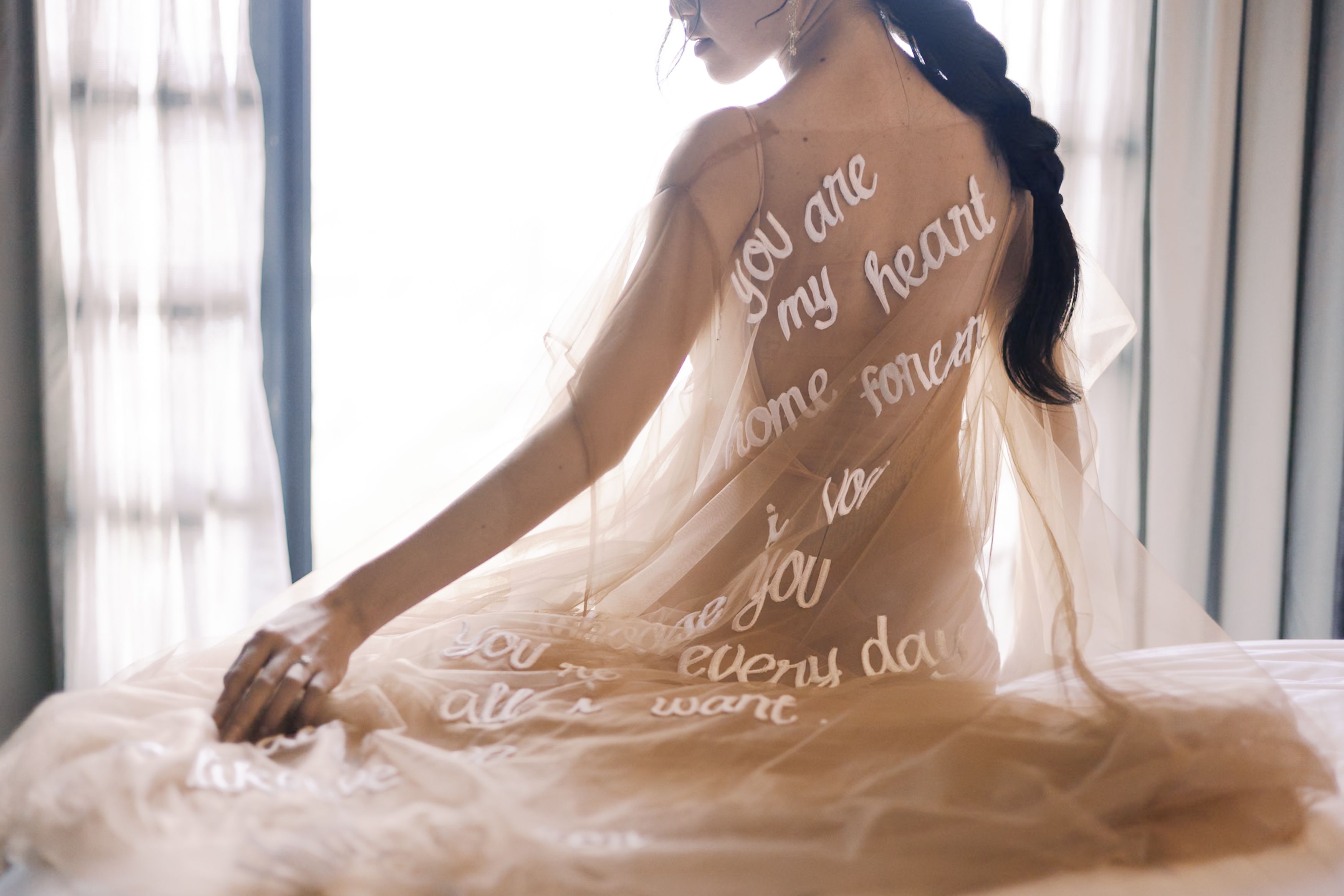  A soft nude robe adorned with delicate word embroidery, adding a personal and elegant touch to the bridal preparation experience.